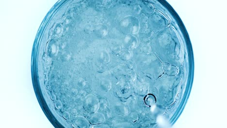 pouring fresh pure sparkling water from bottle into a glass. bubbles in water on super slow motion.