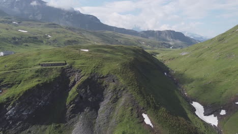 Toma-Aérea-Cinematográfica-Del-Pintoresco-Paisaje-Montañoso-Que-Rodea-El-Col-Du-Petit-saint-bernard-En-El-Valle-De-Aosta-En-Un-Día-De-Verano-En-Italia