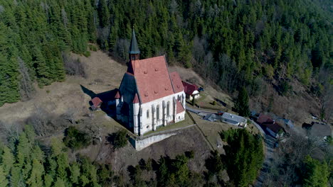 tiro de drone en órbita de una iglesia en una montaña cerca de un pueblo, 4k uhd