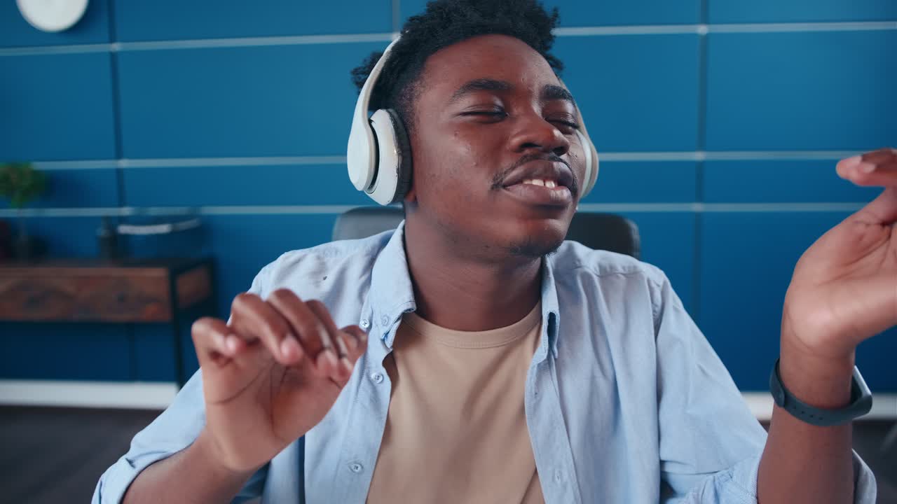 joven afroamericano usa auriculares inalámbricos divirtiéndose escuchando música