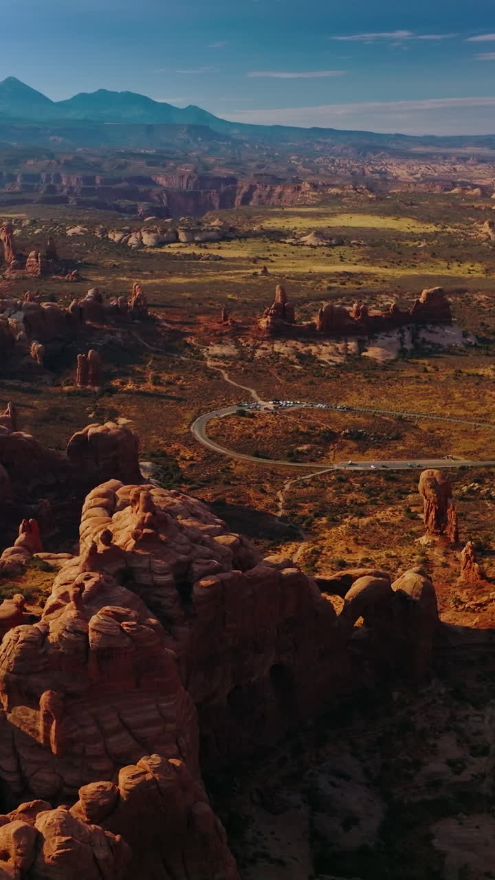Rounded rocks of Arches National park in Utah, USA. Sunny panorama of mountainous valley at the backdrop of blue sky. Top view. Vertical video