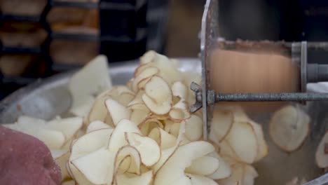 closeup of a potato being cut into curly fries