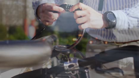 animation of street over hands of caucasian man fastening padlock on bike