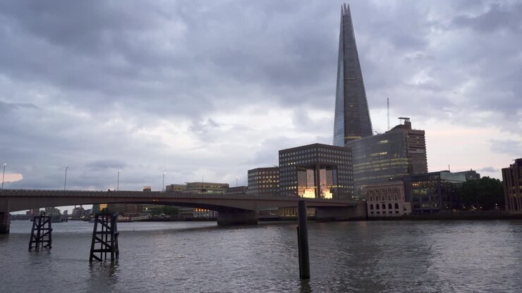 Busy view of London Bridge with the cityscape of the southbank and the Shard skyscraper in the background at dusk