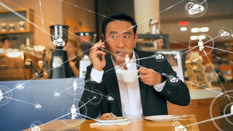 animation of a web connections over biracial man sitting in a cafe