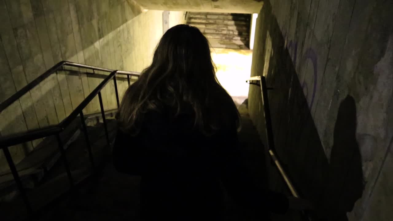 Girl walking down to the underground passage at night