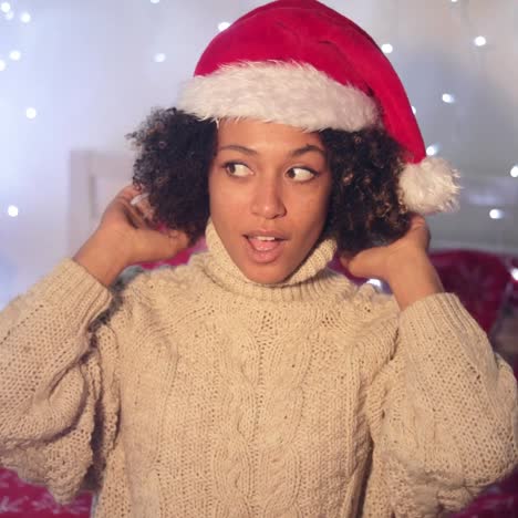 Mujer-Joven-Mirando-El-Pompón-En-Un-Sombrero-De-Santa