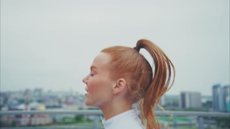 redhead woman running on a rooftop in the city