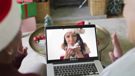 Diversas-Amigas-Mayores-Usando-Una-Computadora-Portátil-Para-Una-Videollamada-Navideña-Con-Una-Mujer-Feliz-En-La-Pantalla