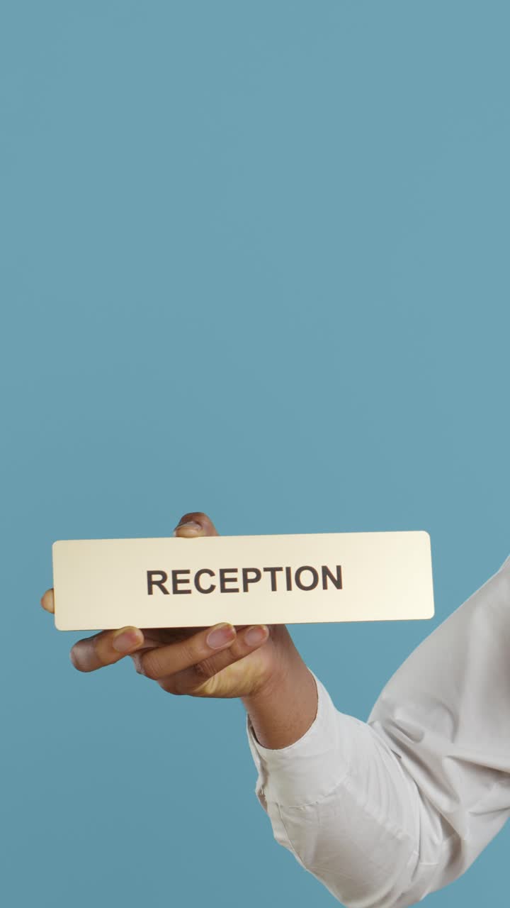 Hand Holding Reception Sign on Blue Background