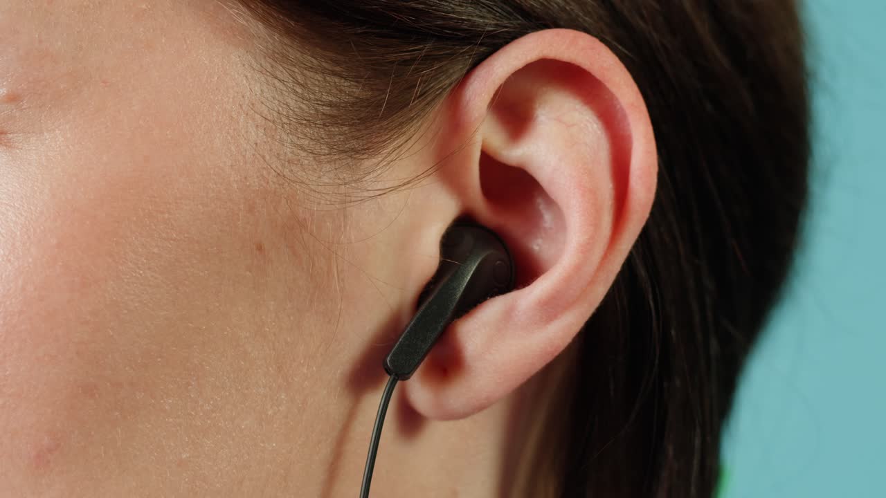 mujer con auriculares en el oído