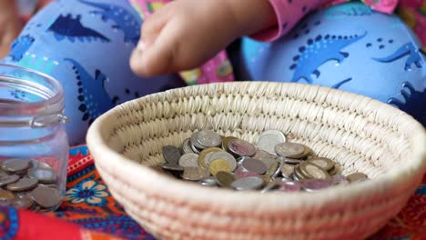 niño ahorrando monedas en una canasta