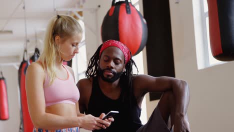 male trainer and female boxer using mobile phone 4k