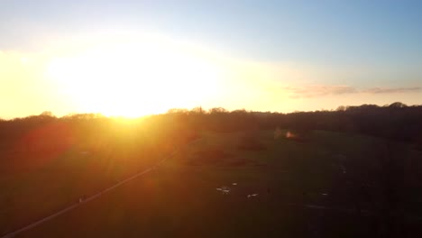 beautiful strong intense sunset with lens flare over green grass park