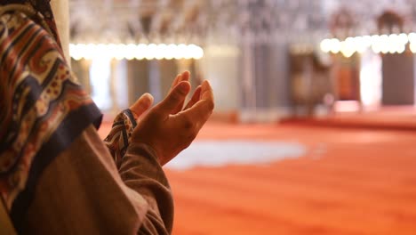 a muslim man praying in a mosque.