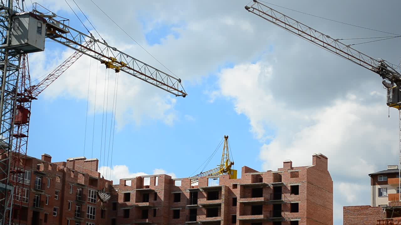 Gru edili sopra le case. Costruzione di edifici residenziali