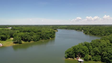 drone footage as it descends from the sky overlooking a body of water in the middle of cottage country