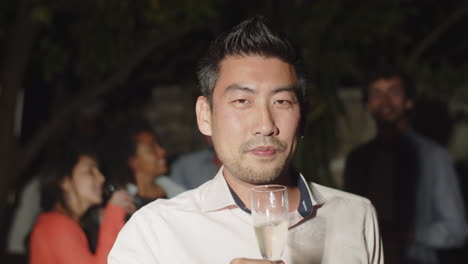 front view of happy guy drinking champagne and looking at camera