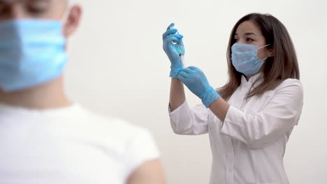 female nurse filling a syringe with a vaccine for covid 19