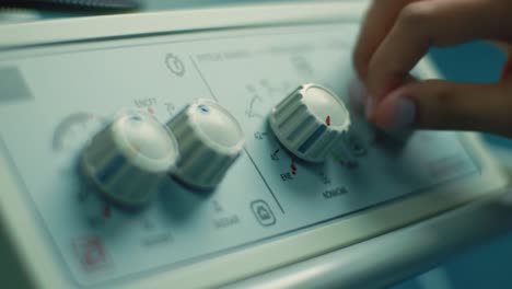 medical staff fine-tune controls on specialized equipment in a hospital. the focus is on patient care as they ensure accurate settings for a procedure.