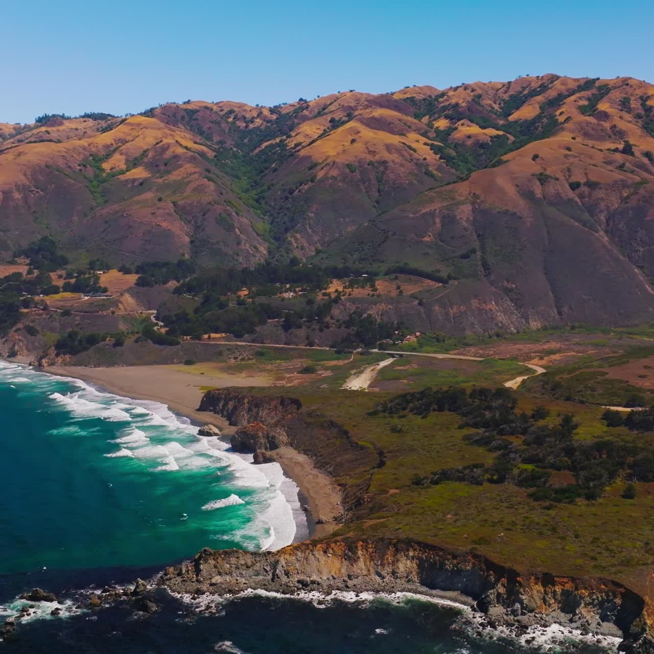 Mountainous shore of Pacific Ocean at Morro Bay, Central Coast of California. Marvelous white waves splashing on the beach. Top view
