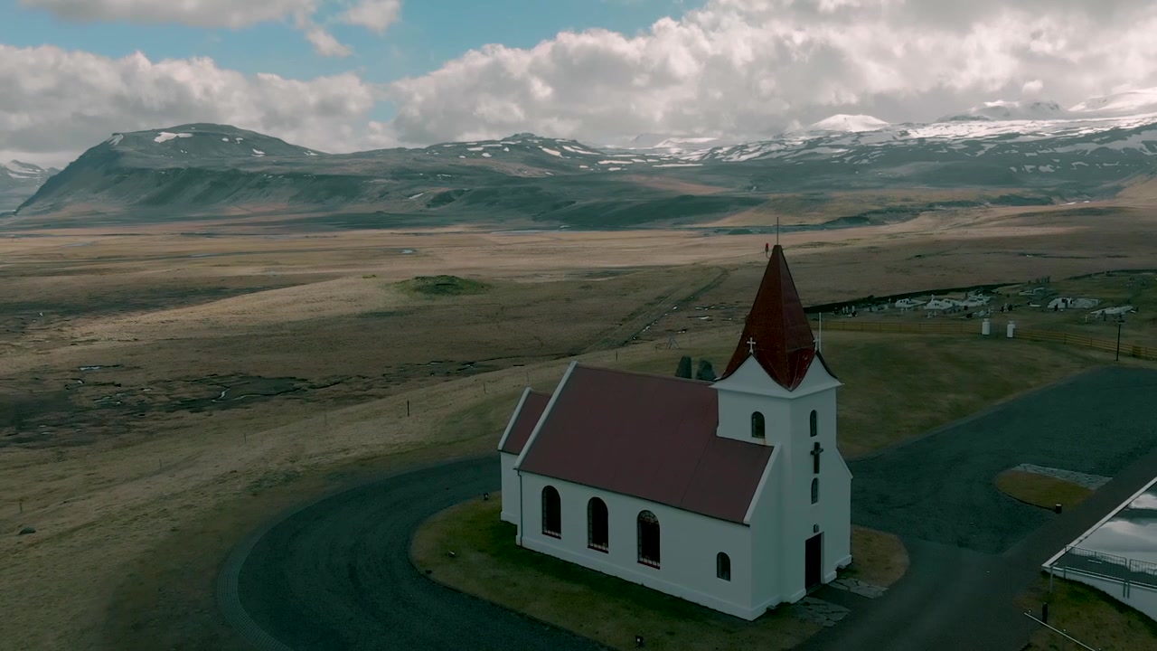 Vista aerea di una chiesa bianca con tetto rosso in un paesaggio rurale islandese