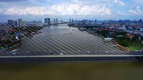 Panning-Aerial-view-of-Rama-VIII-bridge,-illuminated-by-Sun's-spotlight---Bangkok,-Thailand