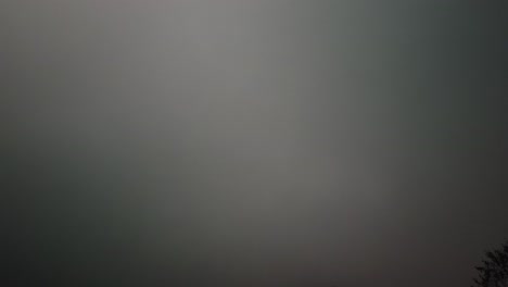 rolling hyperlapse of a fog shrouded hill side, rushing clouds, bleak, gray