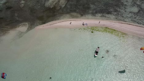 Kite-surfers-at-sardina-island,-los-roques-with-clear-waters-and-sandy-beach,-daylight,-aerial-view