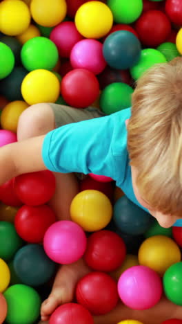 un niño lindo jugando y divirtiéndose en la piscina de pelota