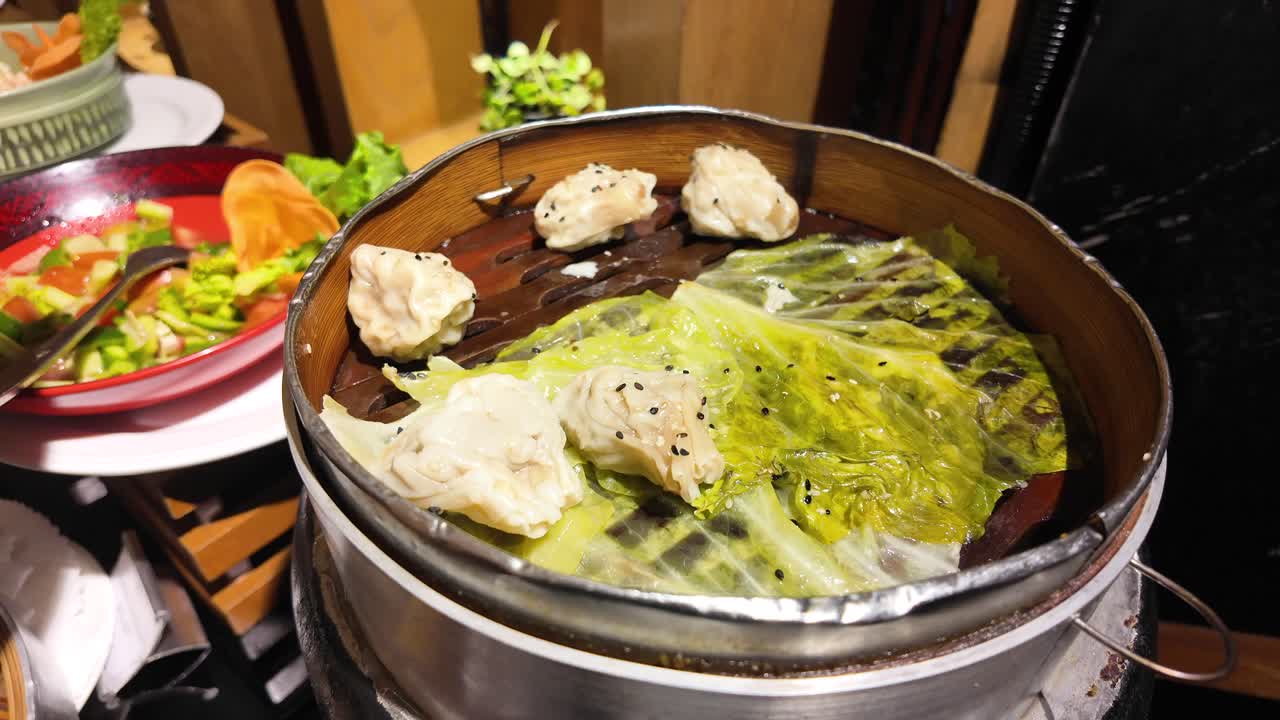 Serving Steamed Siumai (Dim Sum) from a Bamboo Steamer at a Buffet