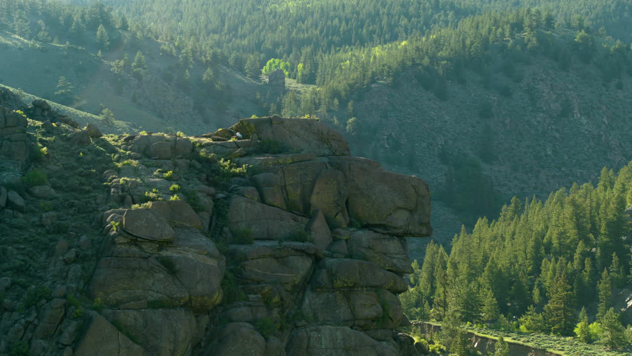 drone aéreo disparado a través de las montañas de colorado con bosques, arroyos y ríos con vías férreas a través de la llamarada solar