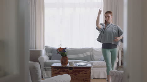 hermosa mujer bailando en casa practicando movimientos de ballet divirtiéndose ensayando en la sala de estar