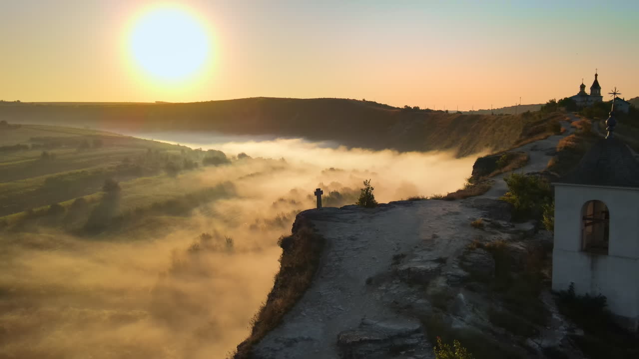 Aerial drone view of the Old Orhei at sunset. Valley with river and fog, monastery located on a hill in Moldova
