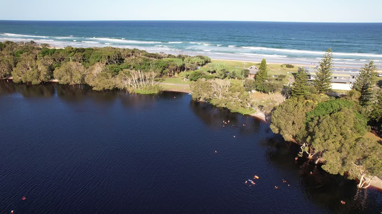 Tourists Swimming On Shallow Freshwater Of Lake Ainsworth Near Lennox Head, NSW, Australia. Aerial Drone Shot
