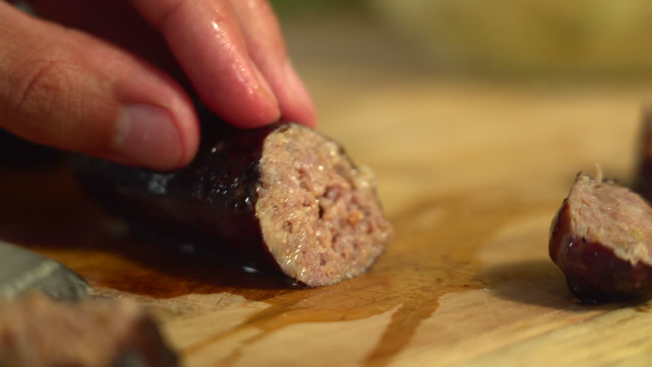 el chef corta una salchicha asada y exprime el jugo