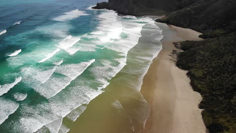 Drohne-Fliegt-über-Dem-Werahi-Strand-In-Richtung-Meer-Und-Zeigt-Den-Leuchtturm-In-Der-Ferne,-Während-Sie-Sich-Nach-Oben-Neigt