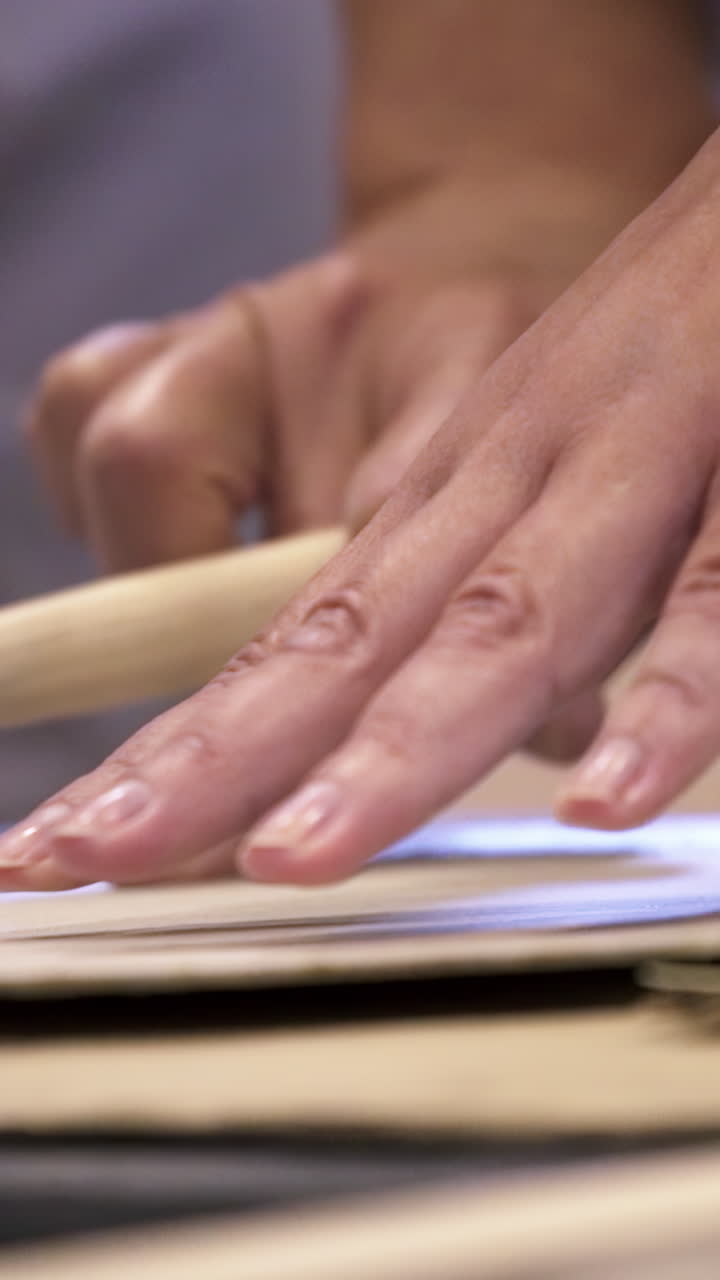 крупный план чьих-то рук, работающих с кистью и бумагой