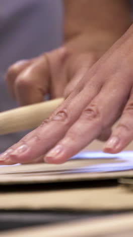 close-up of someone's hands working with a brush and paper