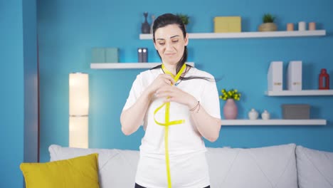 persona infeliz midiendo su peso con una cinta métrica.