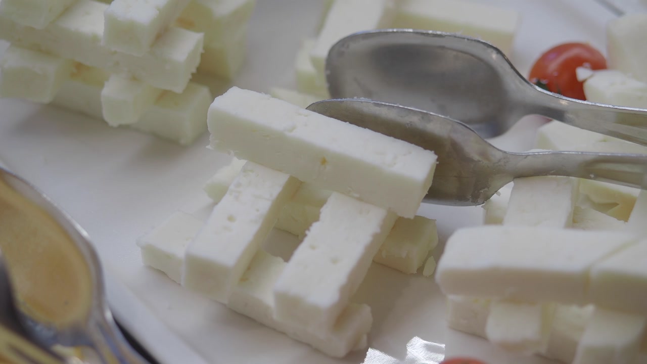 Close-up of White Feta Cheese Sticks and Tongs at a Buffet
