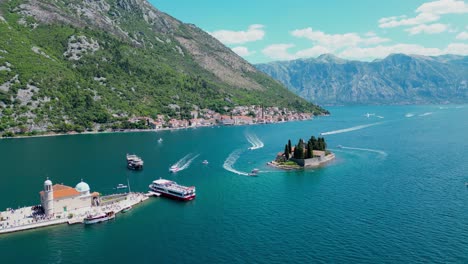 aerial drone view of sveti dorde island. famous travel destination in montenegro. church of our lady of škrpjela and saint george monastery. perast city in background. drone track right. boats passing