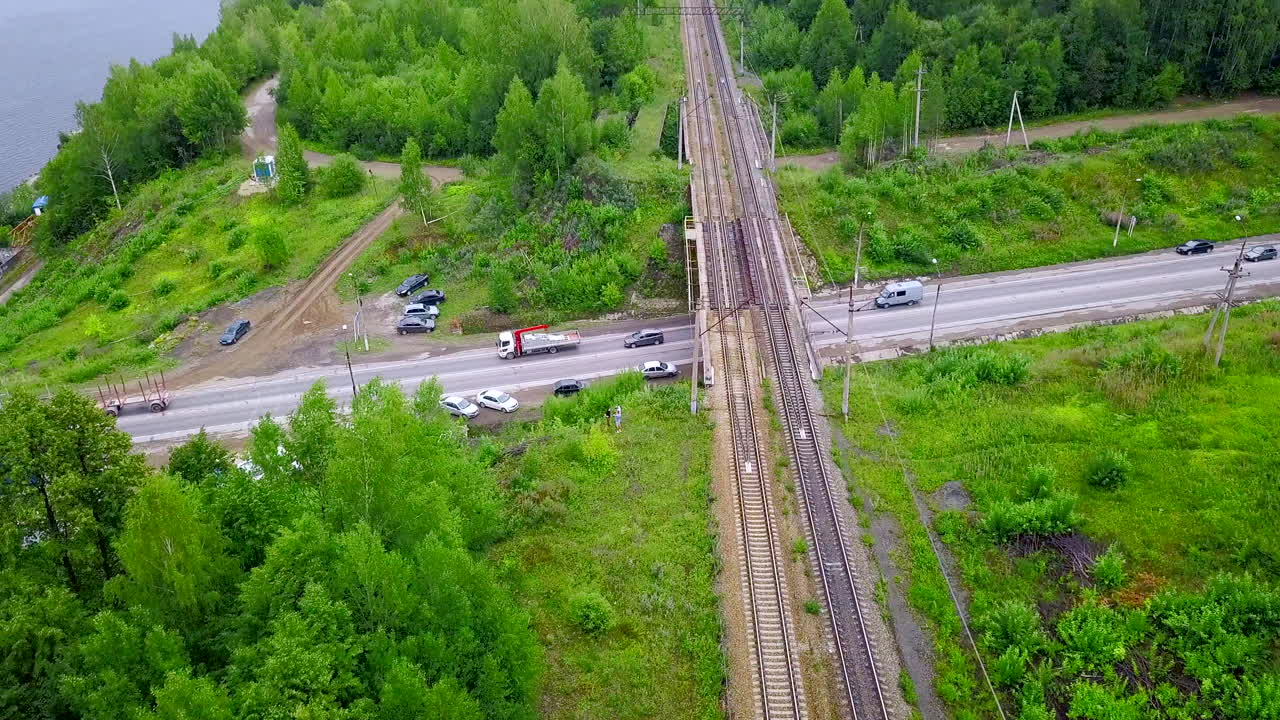 숲 속 의 강 을 가로지르는 도로 와 기차 트랙 의 교차점