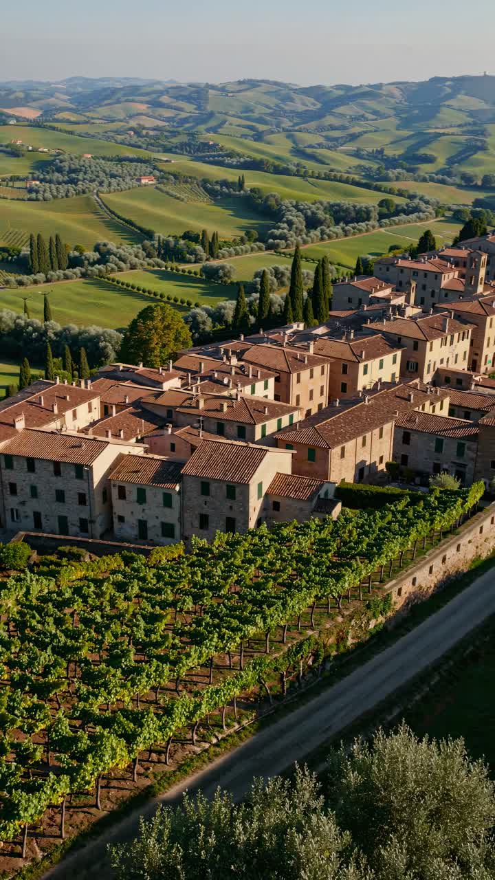 Aerial video captures a picturesque Italian village nestled in rolling hills, showcasing rustic