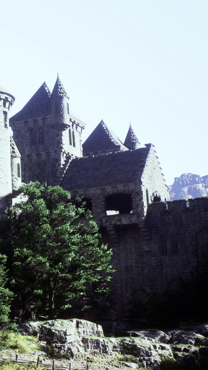 Castello su una collina contro un cielo sereno con montagne sullo sfondo.