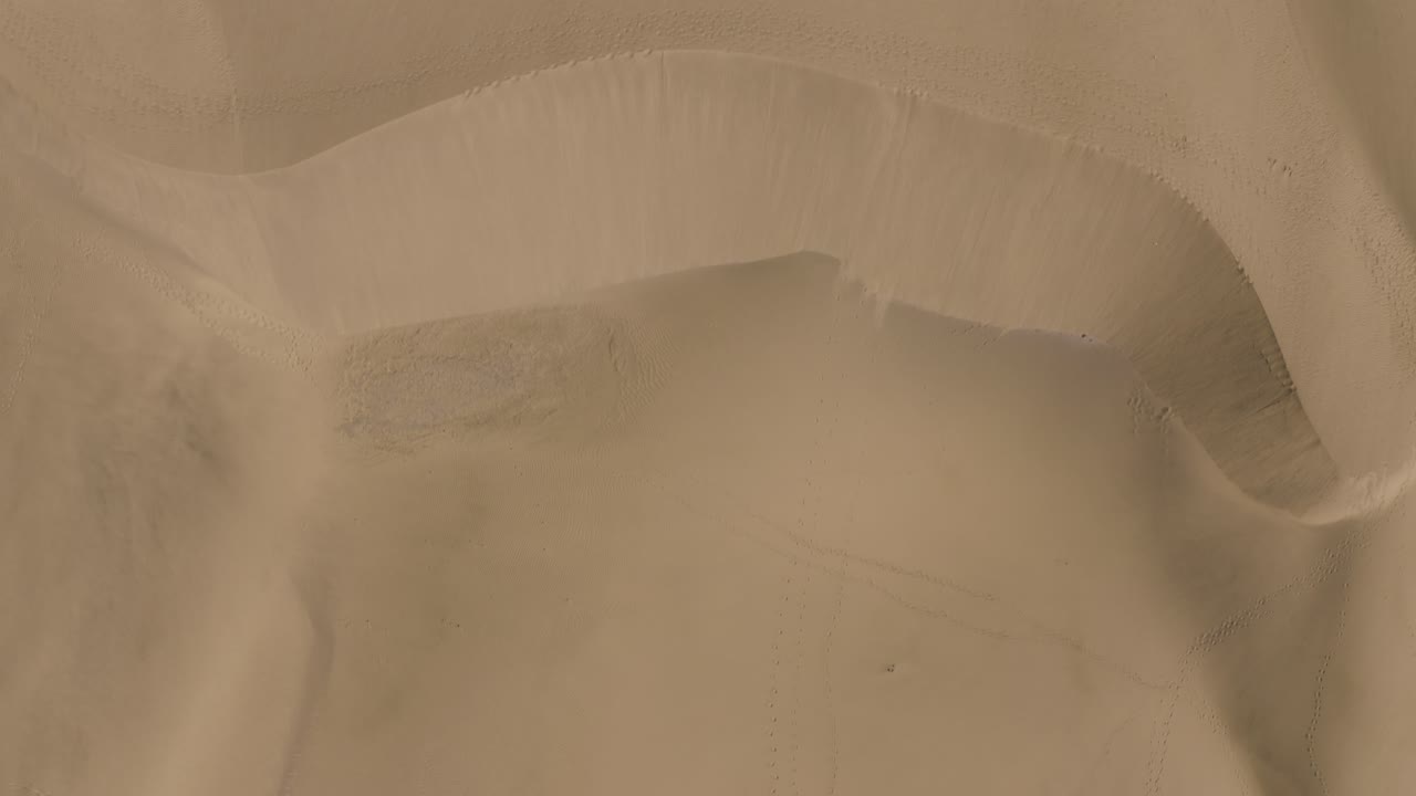 바람 부는 모래가 있는 사막에 있는 모래 언덕의 드론 탑 샷