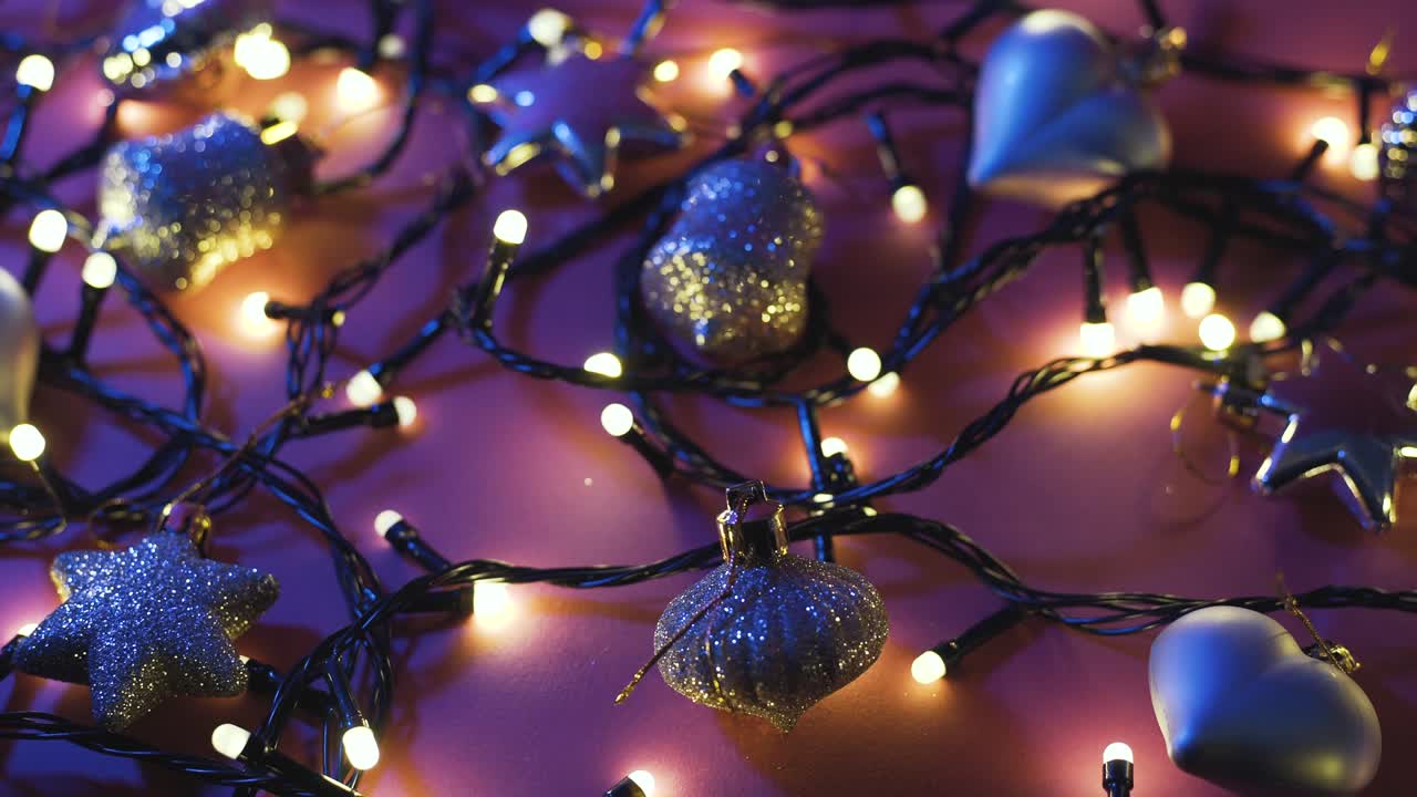 fotografía de cerca de la guirnalda con luces doradas y juguetes navideños en fondo de color. concepto navideño. decoración del hogar. hermoso bokeh