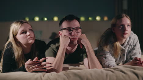 family watching tv in bed