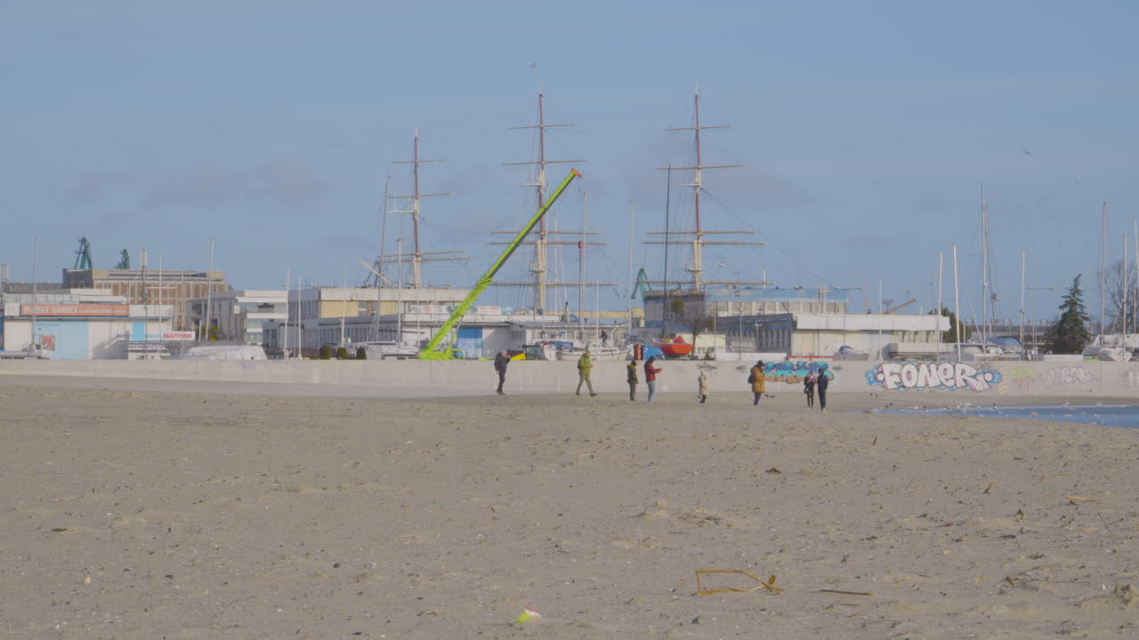 그디니아 센터 모래 해변에서 발트해를 따라 걷는 아이들과 함께 사람들의 먼 전망