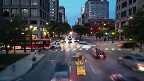 the vibrant atmosphere of a bustling city as cars navigate the streets and pedestrians cross the crosswalks during dusk. the lights from buildings and vehicles create a lively urban scene.
